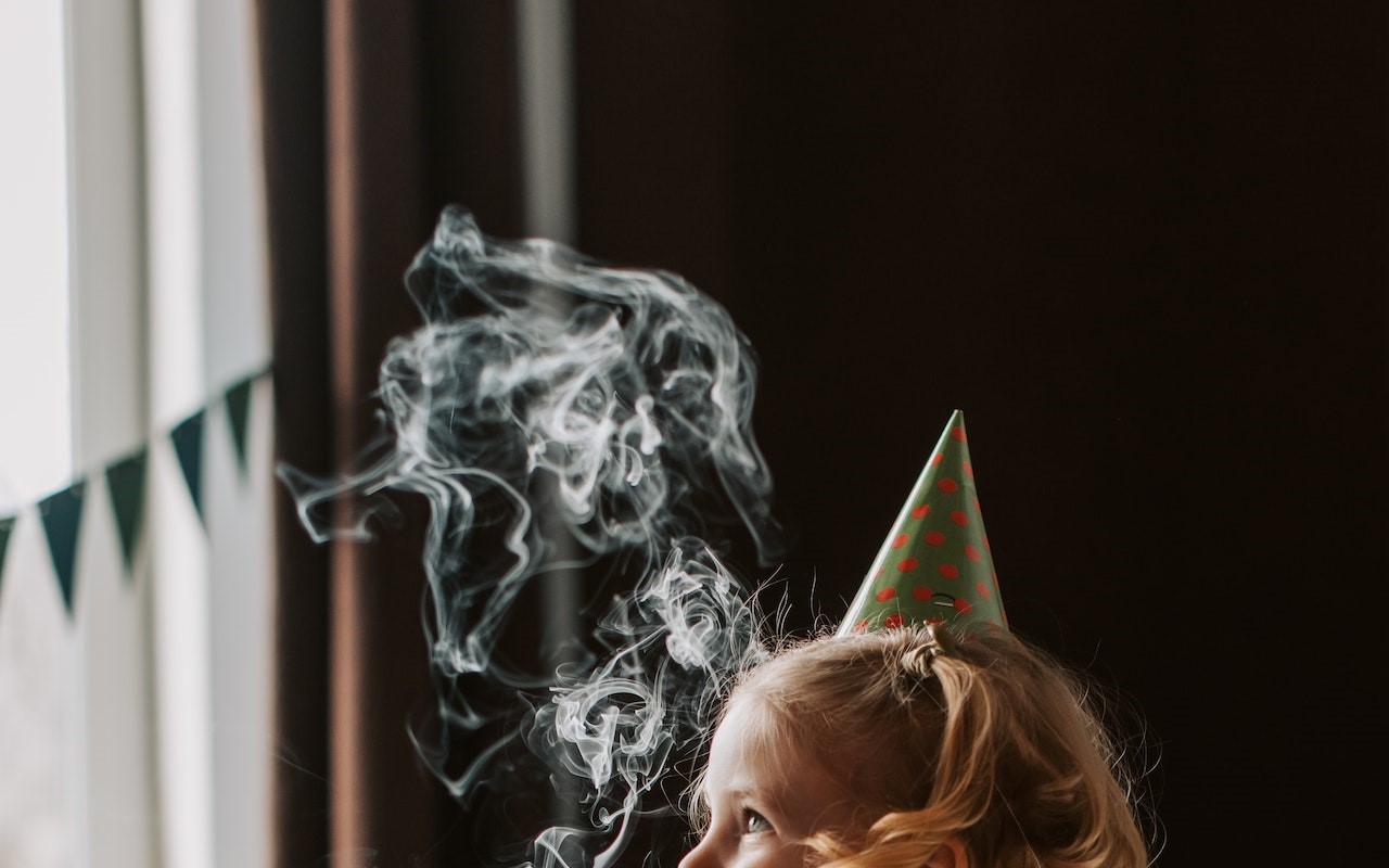 Nad głową małej dziewczynki unosi się tytoniowy dym