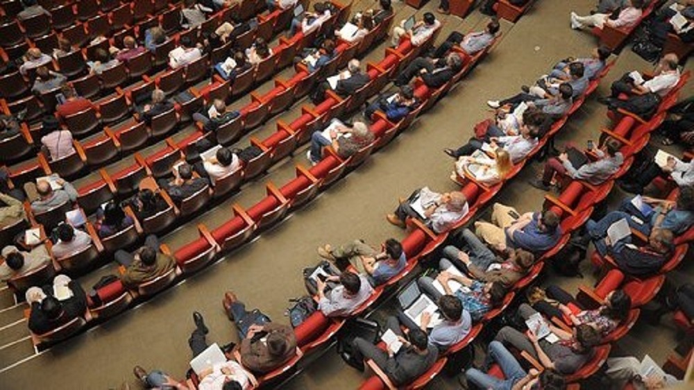 Ludzie siedzący w krzesłach na sali konferencyjnej
