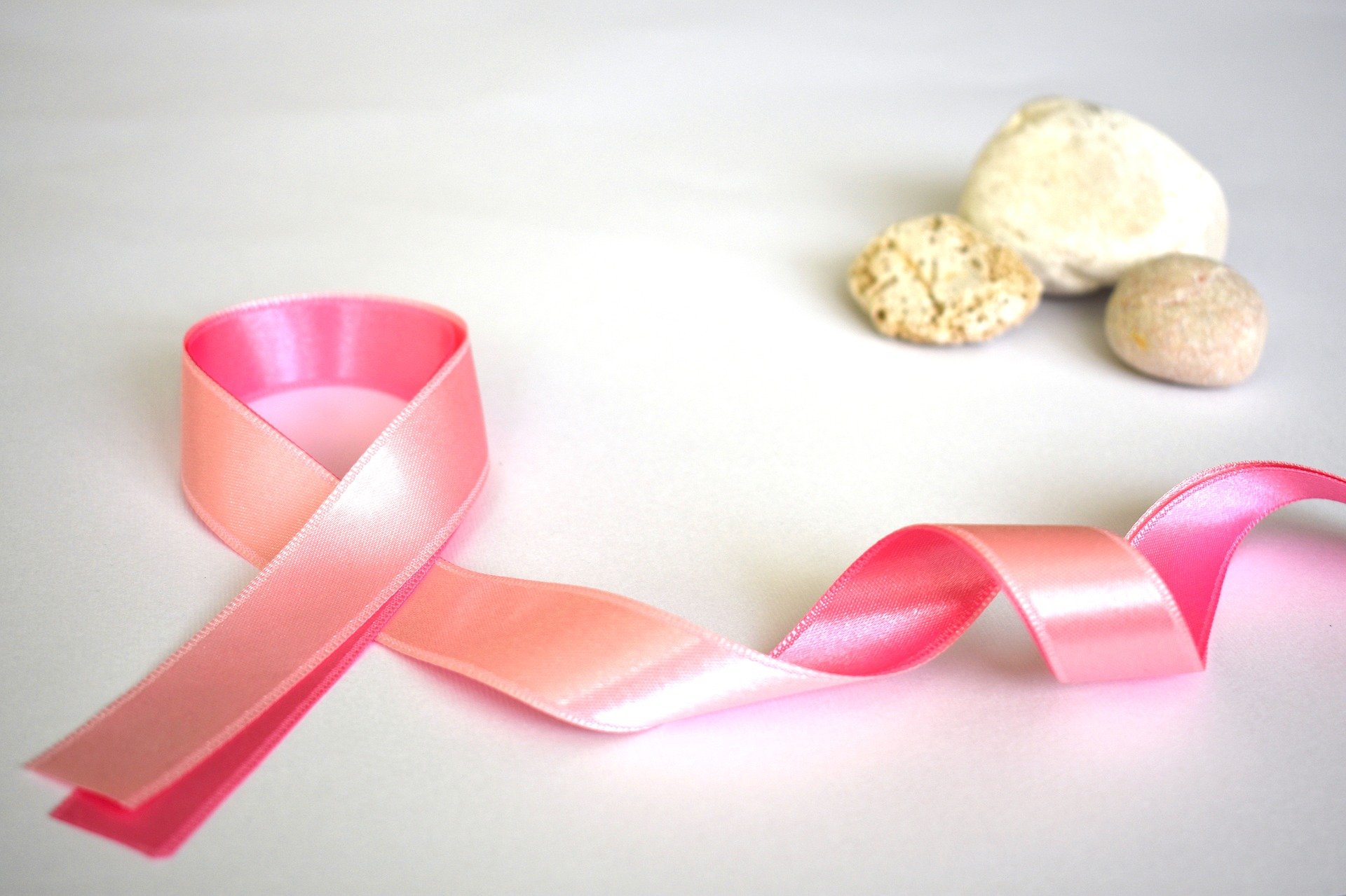 Różowa wstążka na białym tle, symbolizująca walkę z rakiem piersi