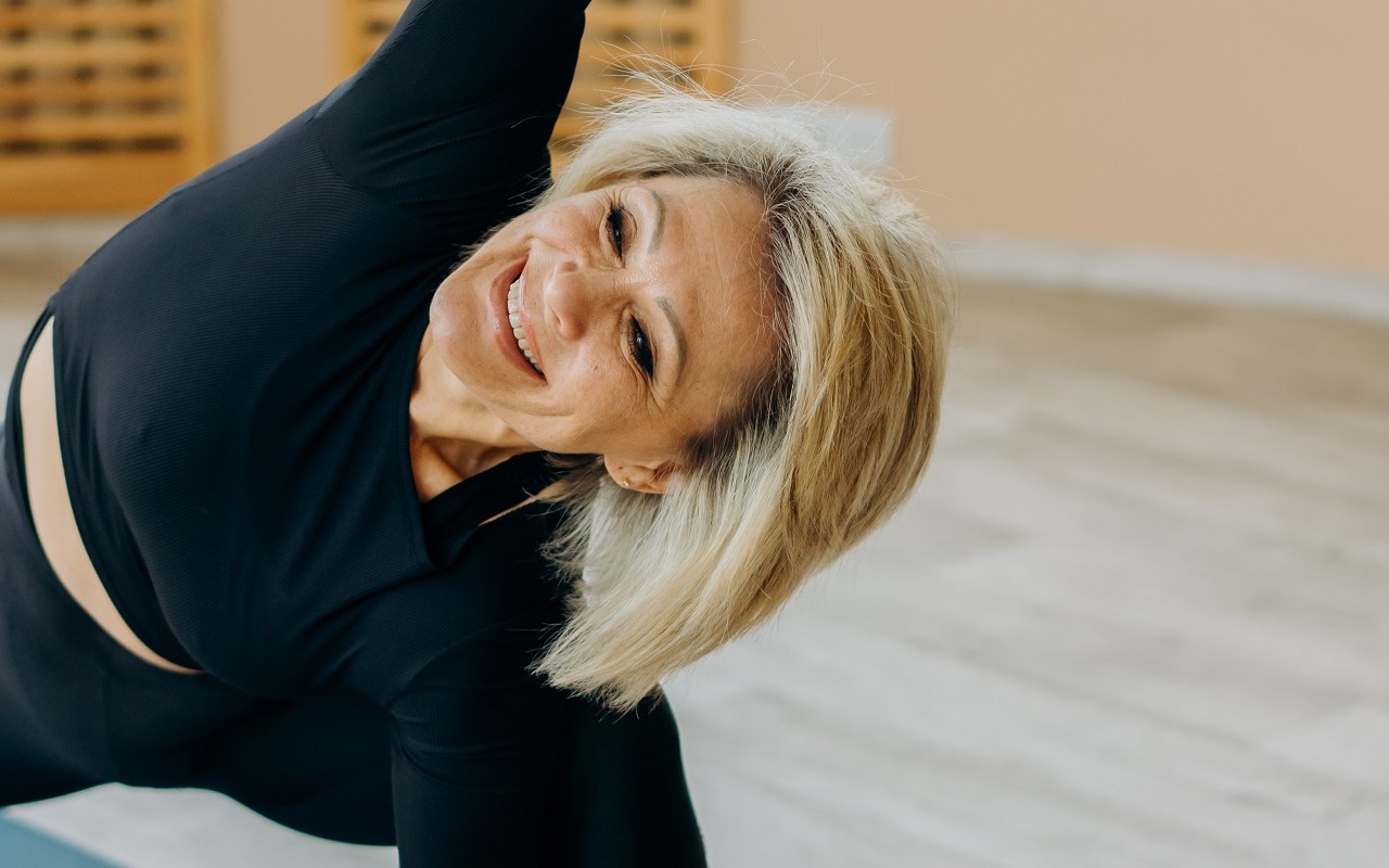 Kobieta w średnim wieku wykonuje ćwiczenia gimnastyczne