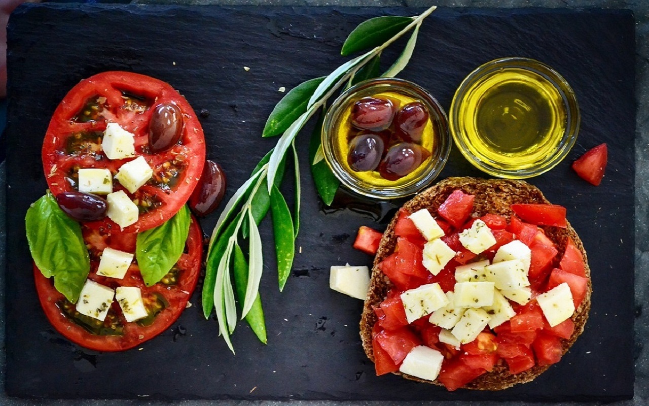 Elementy diety śródziemnomorskiej: oliwa, oliwki, pomidory i feta na kanapkach