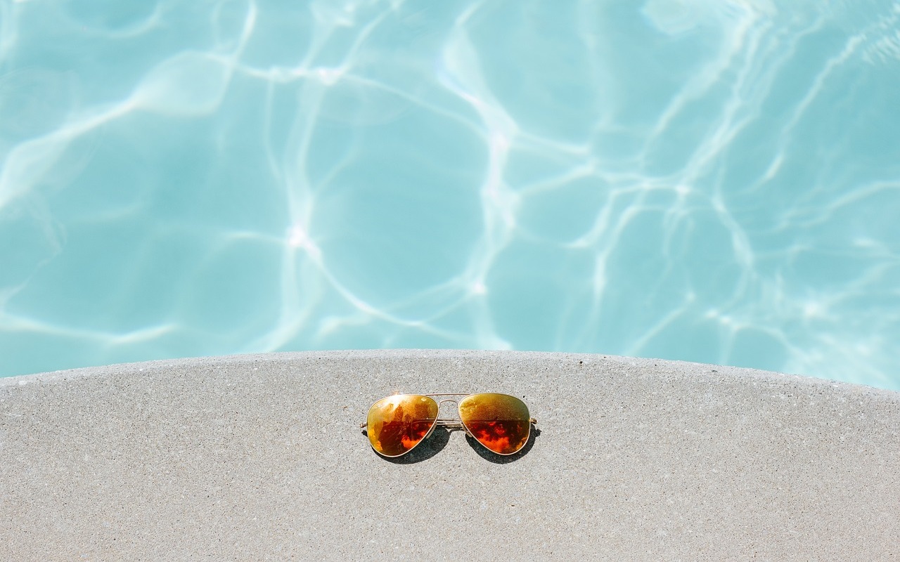 Okulary przeciwsłoneczne leżące na brzegu basenu
